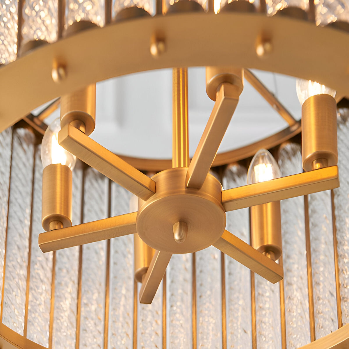 Close-up of the Cliffdale 6 Light Pendant in matt gold, showing the star-shaped centre hub with six arms and E14 bulb holders amid twisted glass rods.