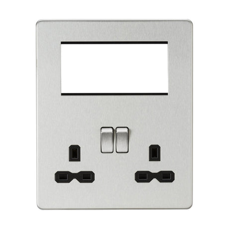 The Small Multimedia Combination Plate - Brushed Chrome (Black Insert) features a sleek, metallic wall design without visible screws. It includes two rocker switches and two sets of three-pin power sockets. The top section has an empty rectangular slot for modular inserts, perfect for USB charging or other components.