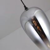 A close-up of the Slice Glass Pendant Light in chrome, showcasing its modern design with a reflective surface and the bulb subtly visible inside as it hangs from the ceiling.