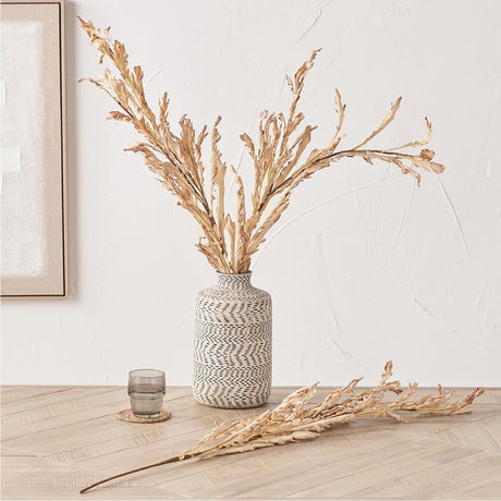 Natural Apricot Autumn Leaf artificial flower stems, pack of 6, arranged in a patterned vase with one stem laid on a wooden floor in a light-toned room.