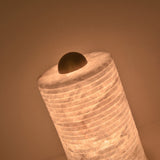 Aurelior Small LED table lamp with ribbed alabaster cylindrical body glowing warm white, topped with a rounded brass cap, shown close-up against a plain background.