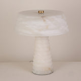 Orivon 3 Light Sculpted Alabaster Table Lamp in soft white, with a ribbed tapered base and banded drum-form shade joined by a brass finial, shown on a plain light background.