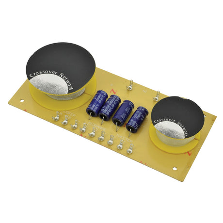 Image of the QTX 3-Way Crossover 6db, 8 Ohms - 400W circuit board highlighting a high-quality 3-way crossover. Two prominent round black components labeled 'Crossover Network' are included, along with several cylindrical capacitors and soldered connections on a yellow base, designed to ensure excellent sound reproduction.