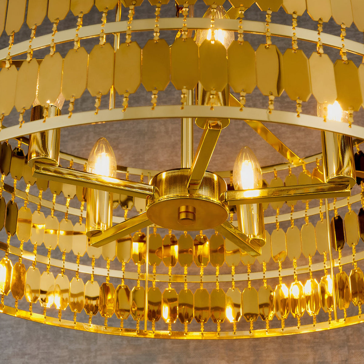 Brackhurst 5 Light Pendant in gold, close-up of central star-shaped arm with candle bulbs and tiered hexagonal plate strands cascading around it.