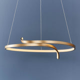 Endon Chartmont pendant light in matt brushed gold, a slim curled ring with integrated LED and frosted diffuser, suspended against a blue wall.