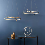 Endon Chartmont pendant in matt brushed gold, a slim looped ring with integrated LED, shown with a silver version above a mirrored side table.