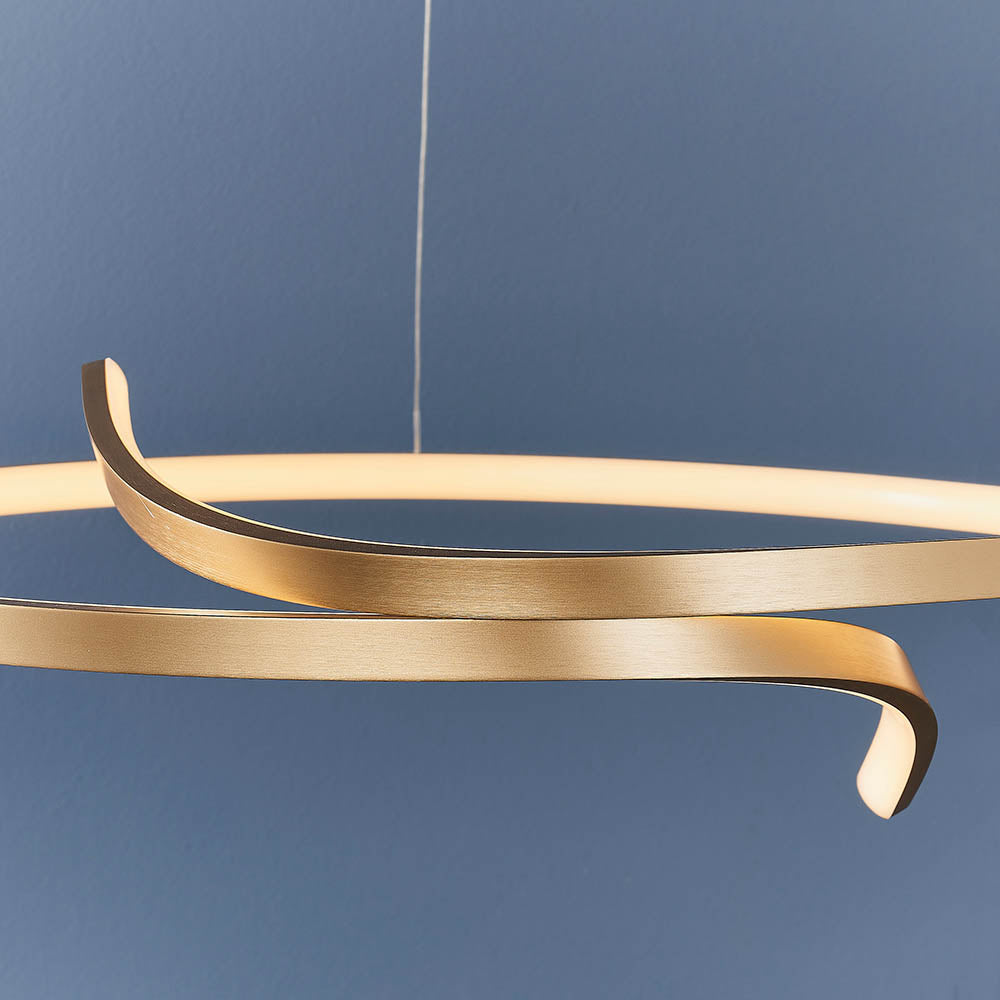 Endon Chartmont pendant light in matt brushed gold, close-up of the looped ring form with frosted LED diffuser against a deep blue wall.