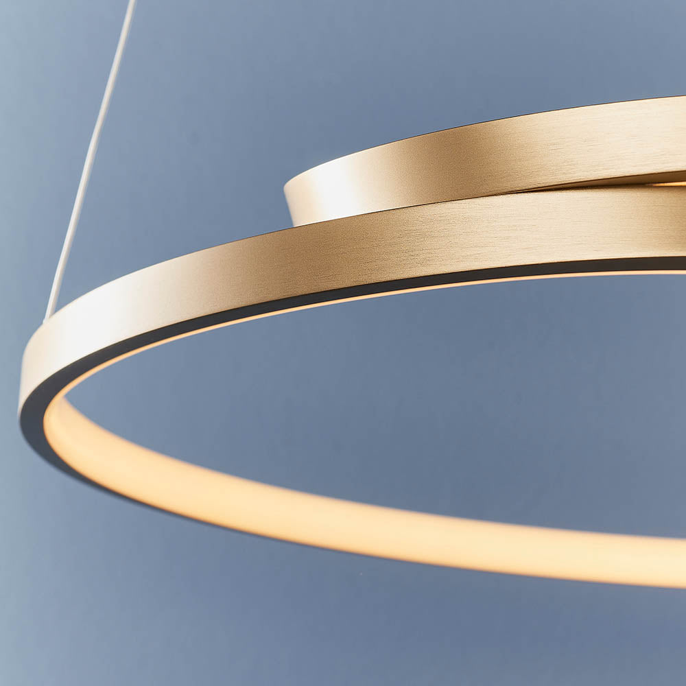 Close-up of the Endon Chartmont pendant ring in matt brushed gold, showing the slim profile and frosted LED diffuser against a blue background.