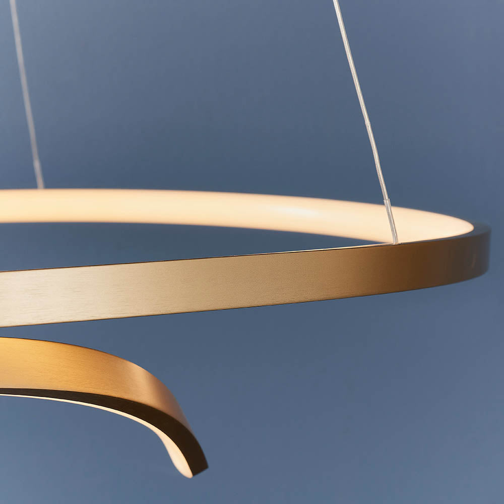 Close-up of the Endon Chartmont pendant showing its slim matt brushed gold ring and frosted diffuser against a deep blue background.