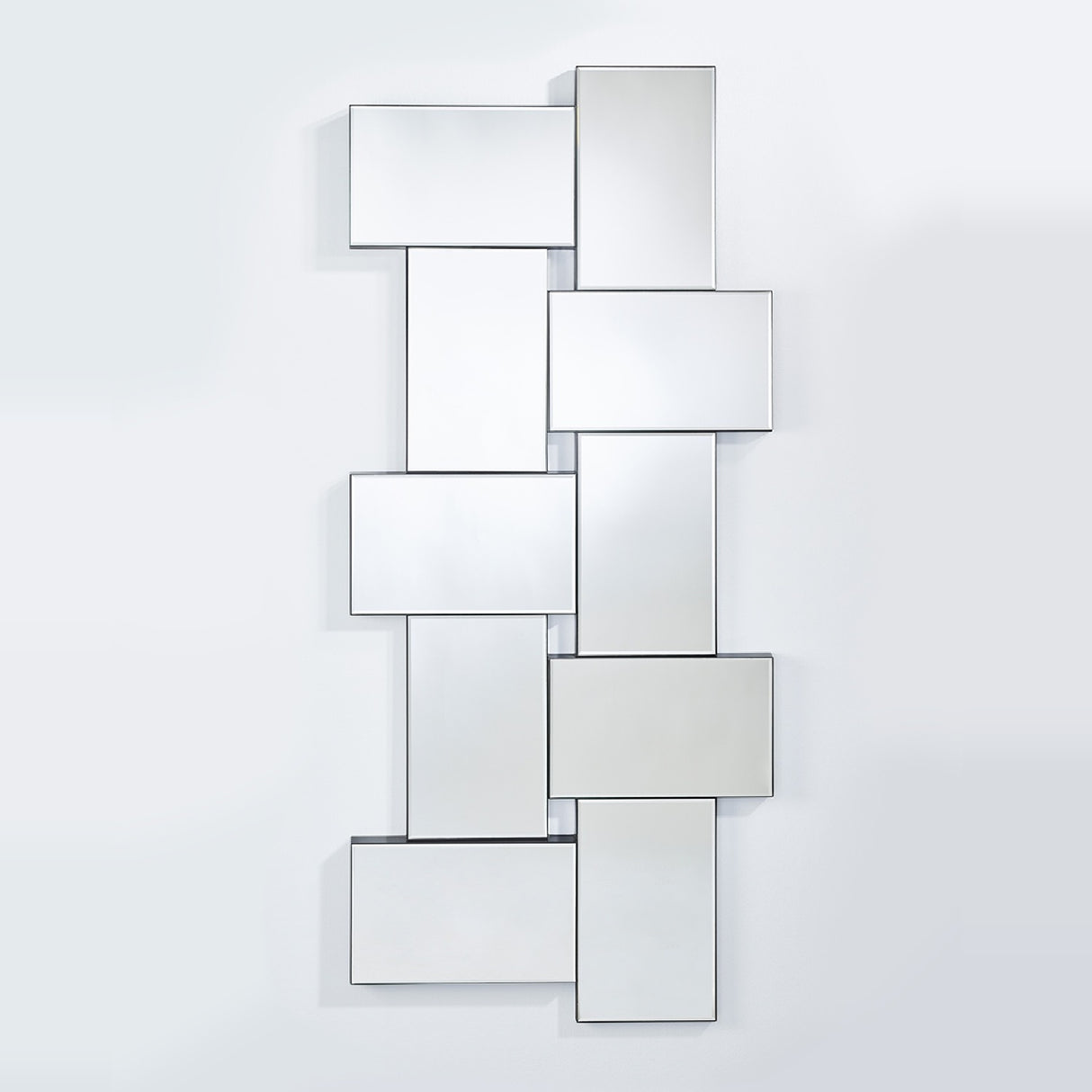 The panelled mirror seen larger, the panels stepping forward at different depths with openings between them.