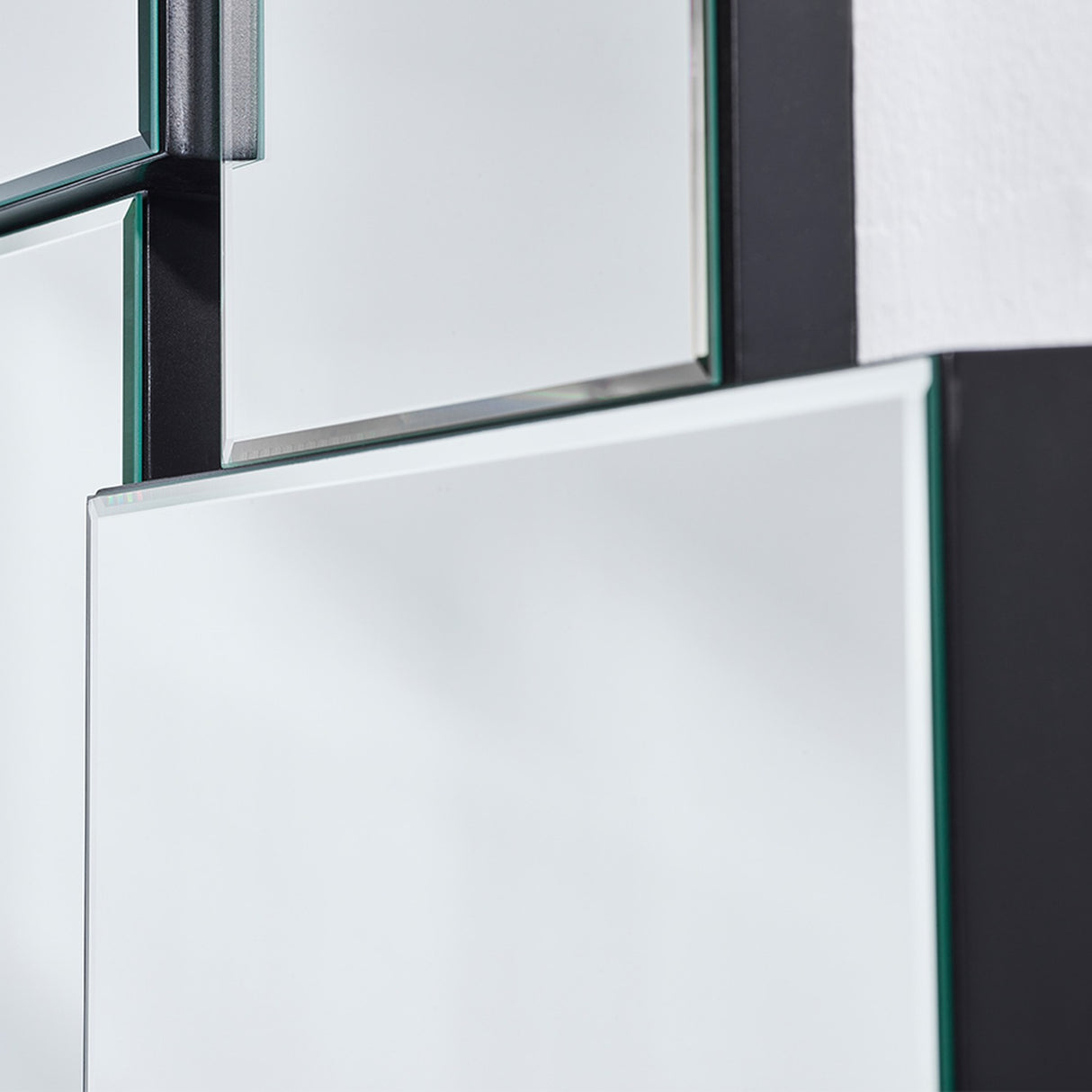 Close-up of the panel corners where they overlap, the green glass edges and black support visible.