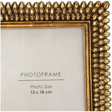 Libra Interiors Textured Beaded Gold Photo Frame shown in close-up, with raised resin beadwork bordering a 13x18cm aperture in a warm gold finish.