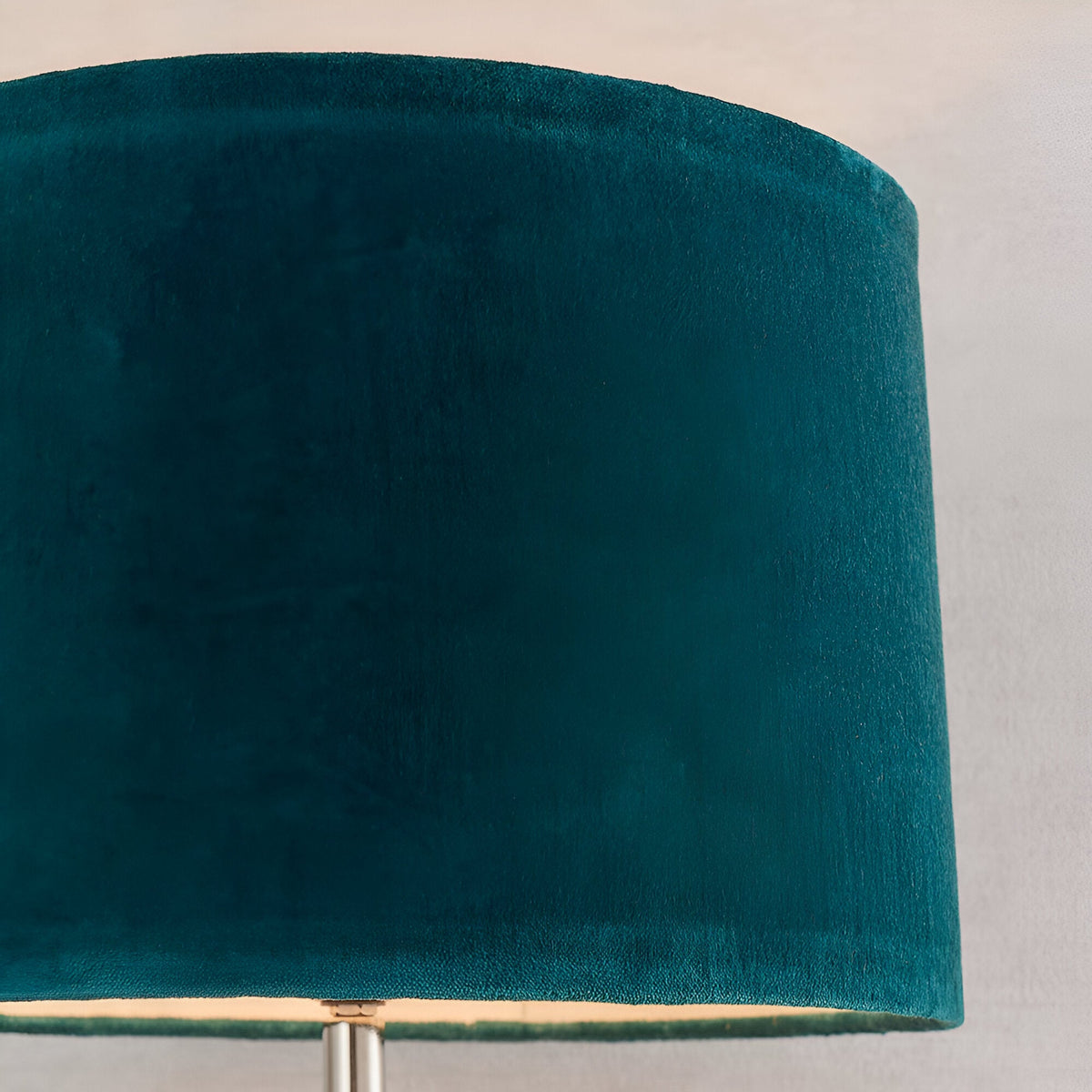 Close-up of the Endon Danehurst table lamp's teal velvet tapered shade with visible nickel stem below, against a light neutral background.