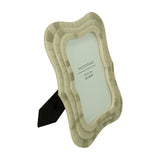 Libra Interiors ivory mosaic tiled resin photo frame with wave-shaped scalloped border, textured tiled finish, and rear stand, on a white background.