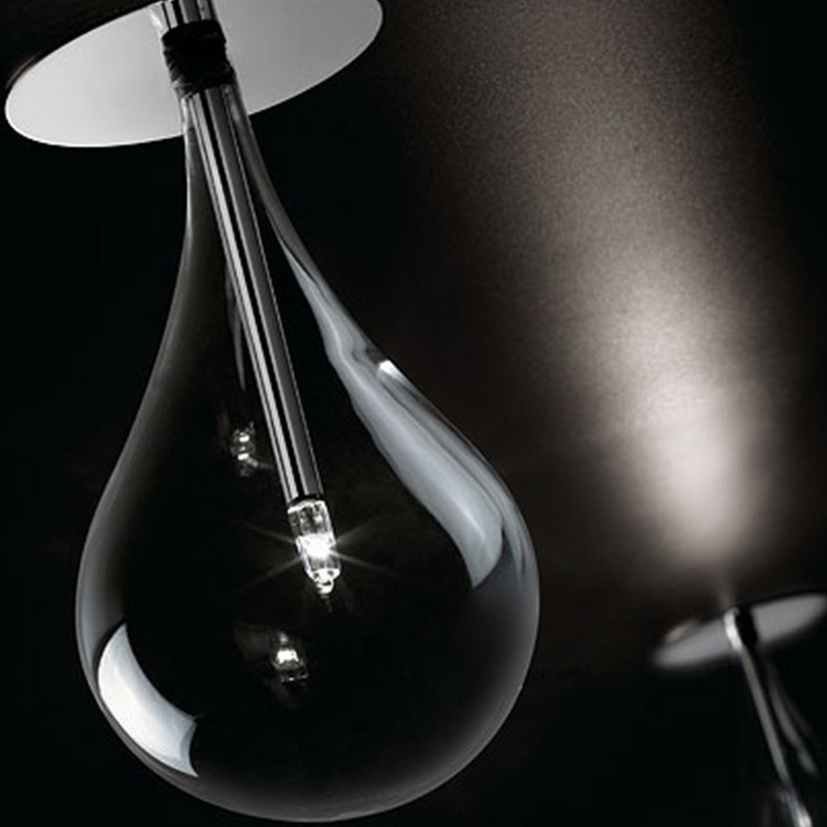 Yarvelle Glass Downlight in chrome, a clear teardrop glass shade with a slim chrome rod and G4 bulb glowing low inside, mounted on a flush chrome ceiling plate.