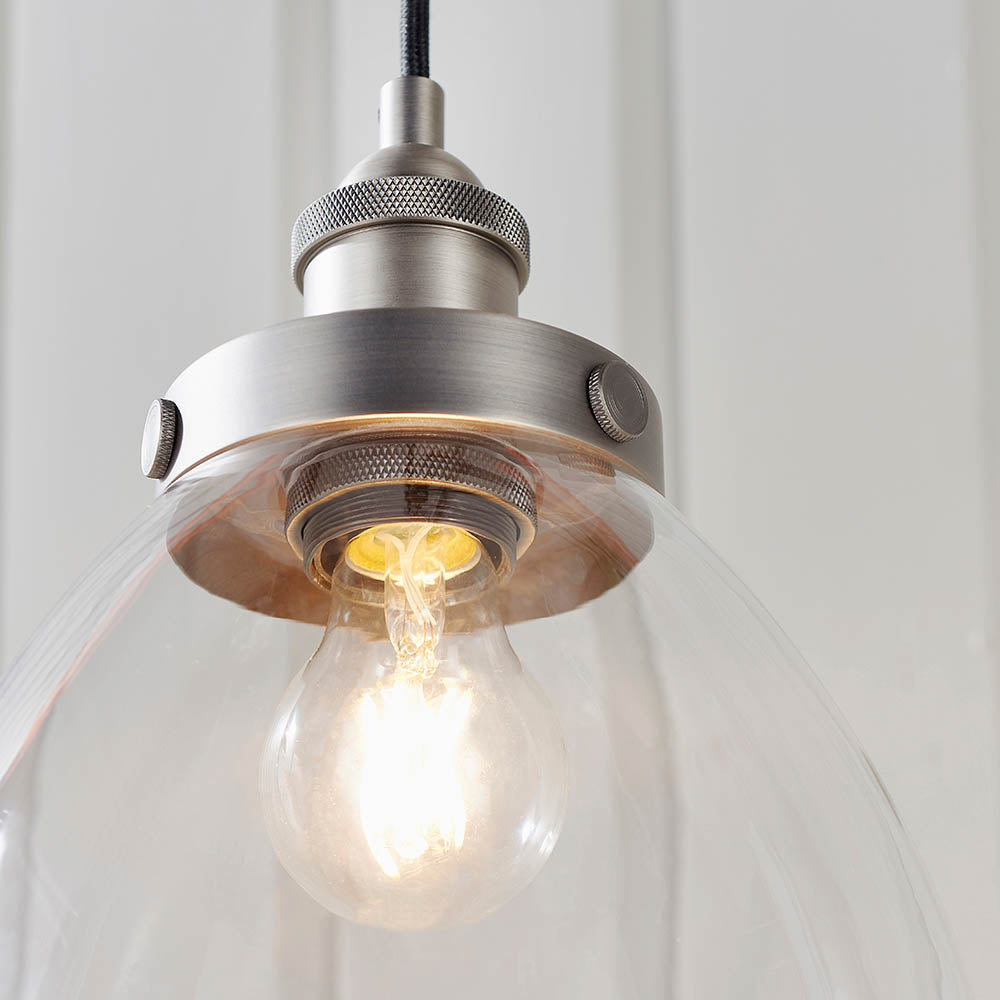 Wentworth Pendant Light in silver, showing a clear glass bell shade with knurled metal lamp holder and exposed filament bulb, industrial style.