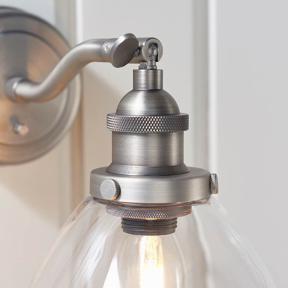 Wentworth Wall Light in silver, close-up of the adjustable knuckle joint, knurled lamp holder and clear glass shade with visible bulb.