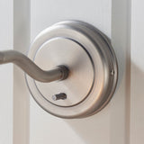 Wentworth Wall Light in silver, close-up of the round base plate and adjustable arm with knurled details, mounted on a white panelled wall.