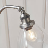 Close-up of the Endon Wentworth table lamp's brushed silver head with knurled holder, adjustable knuckle, clear glass shade and filament bulb.