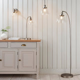 Endon Wentworth silver floor lamp with arched stem and clear glass shade, shown beside a cream sideboard with matching wall light, table lamp and pendant.