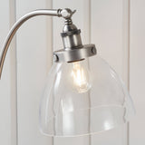 Endon Wentworth silver floor lamp close-up showing knurled brushed metal holder, adjustable knuckle and clear glass dome shade with visible filament bulb.