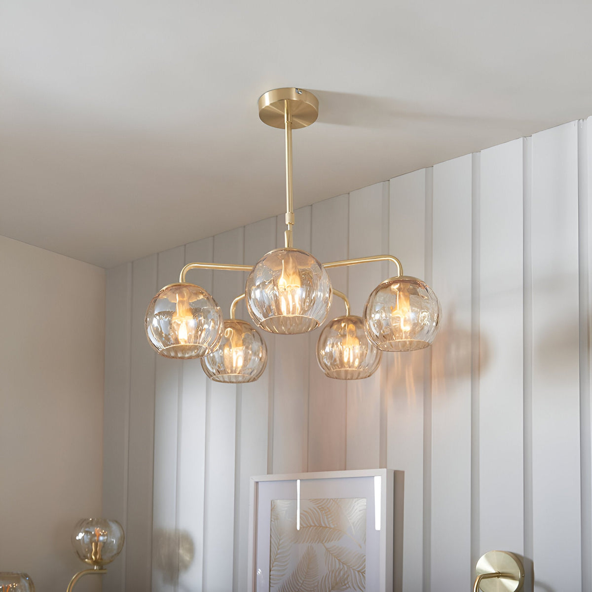 Endon Draycott 5 light pendant with dimpled champagne glass globe shades on a satin brass frame, installed in a bright neutral interior.