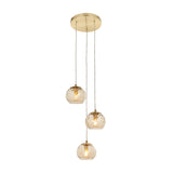 Draycott 3-light cluster pendant with round satin brass ceiling plate and three dimpled champagne glass globe shades on cables, shown on a white background.