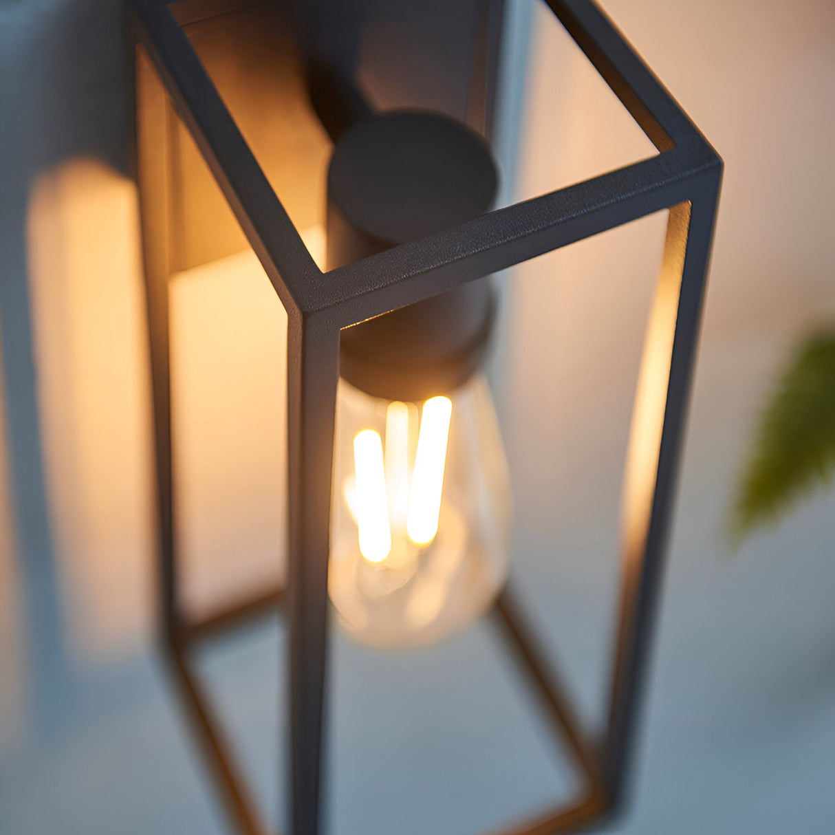Brenford Outdoor Wall Light in black, close-up of the open aluminium lantern frame with a lit E27 filament bulb, IP44 rated.