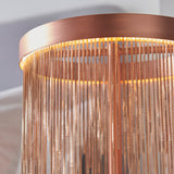 Close-up of the Endon Danestead table lamp showing its brushed copper LED ring and fine copper toned chains hanging at varied lengths, softly lit.