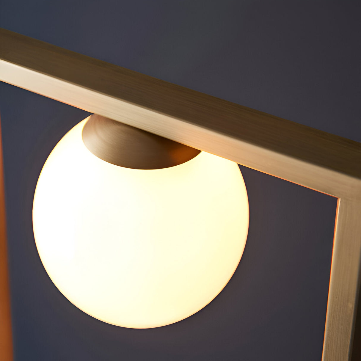 Close-up of the Cranford 3 Light Floor Lamp in brushed gold, showing an opal glass globe glowing beneath an angular metal arm.