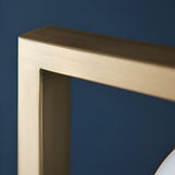 Close-up of the Cranford 3 Light Floor Lamp's brushed gold frame, showing the angular metal joint and grain-textured finish against a dark blue background.