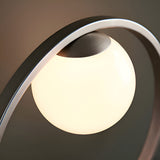 Brackstead Table Lamp in brushed silver, close-up of the interlinking circular frame cradling an illuminated opal glass sphere.