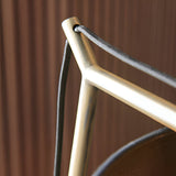 Close-up of the Endon Carlfield table lamp showing the matt brass cantilevered arm joint and black fabric flex against a wood-panelled backdrop.