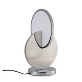 The Half Moon LED Table Lamp - Silver features a modern design with interlocking circular shapes—one metallic silver, one white—set on a chrome base and finished with a sleek black power cord.