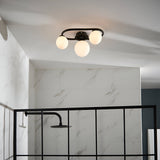 Endon Marden 3 light oval semi-flush bathroom ceiling light in matt black with opal glass globes, mounted above a walk-in shower with black framed screen.