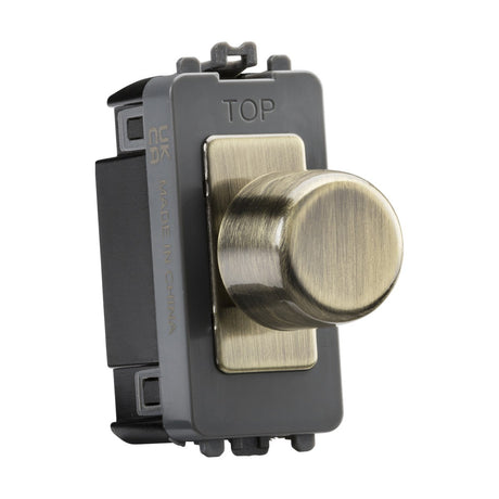 The 6A 1 Gang 2-Way Dummy Dimmer Module - Antique Brass features a metallic rotary dimmer switch in an antique brass finish, mounted on a sleek black rectangular base with the word TOP embossed on one side for correct orientation.