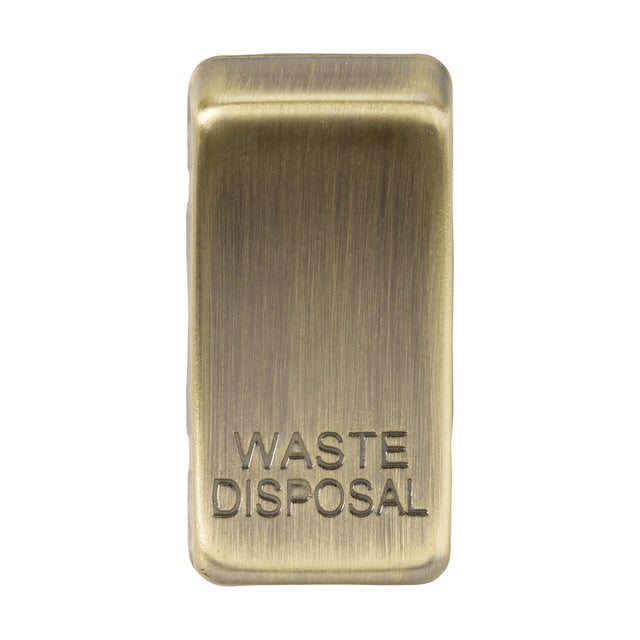 The Switch Cover "Marked WASTE DISPOSAL" in Antique Brass, elegantly designed with engravings, provides a seamless fusion of style and functionality. It belongs to a set that includes interchangeable rocker covers.