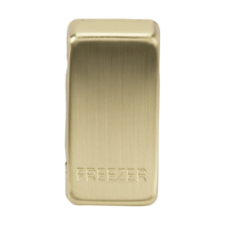 Displayed is the Switch Cover "Marked FREEZER" in brushed brass, featuring a magnetic clip with a smooth metallic surface and the word FREEZER engraved on it. It is designed to securely hold items such as bags closed.