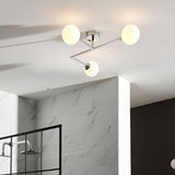 Kelham 3 Light Semi-Flush Bathroom Ceiling Light in chrome with three round opal glass globes on angled arms, installed above a marble-tiled shower area.