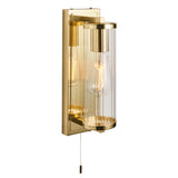 Endon Cranfield IP44 bathroom wall light in brass with ribbed clear glass tube shade, E27 filament bulb and pull cord switch on a plain white background.