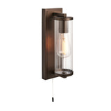 Bronze Cranfield bathroom wall light with rectangular back plate, ribbed clear glass tube shade, visible bulb, and pull-cord switch on white background.