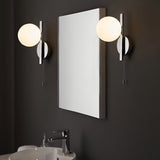 Endon Kelham chrome bathroom wall lights with opal glass globes and pull cords, mounted either side of a rectangular mirror above a basin on a dark wall.