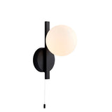 Kelham Bathroom Wall Light in black with an opal glass sphere, slim rectangular arm, round wall plate, and pull cord switch, on white background.