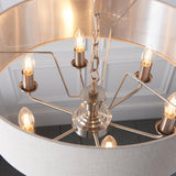 Brenley 6 Light Pendant in chrome, close-up of E14 candle bulbs on splayed arms beneath a linen shade with mirrored inner lining.