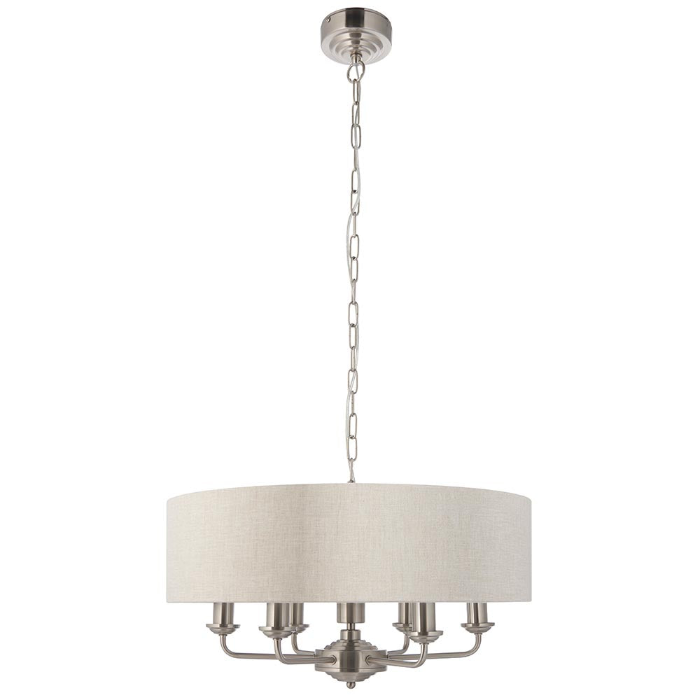Brenley six-light pendant with round drum shade in cream fabric, six chrome candle arms, and a chain suspension, shown on a plain white background.