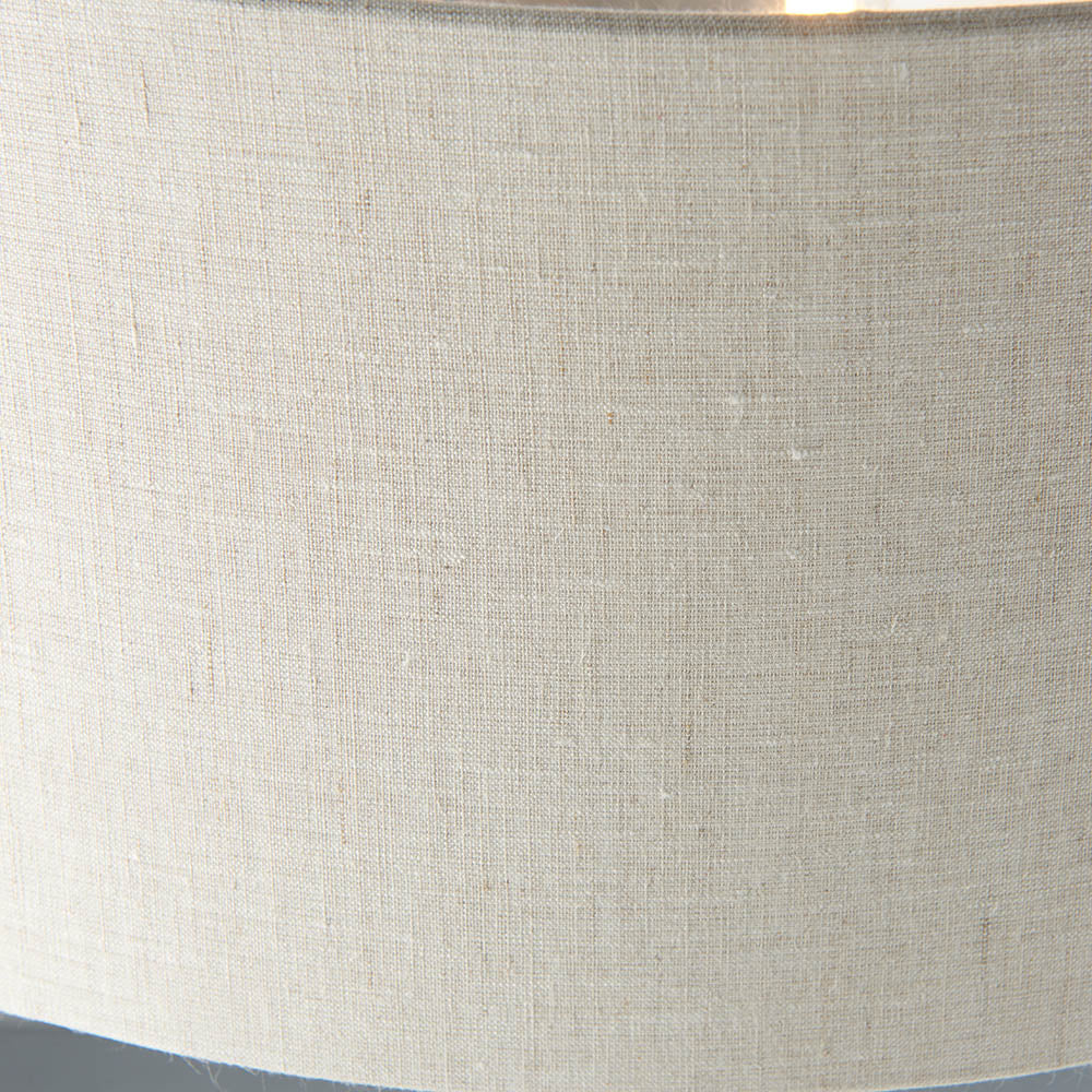 Close-up of the natural linen fabric shade on the Brenley 3 Light Floor Lamp, showing woven texture and brushed chrome trim edge.