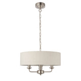 Brenley 3-light pendant with round white fabric drum shade, chrome arms and three candle-style holders, on a chain suspension against a plain white background.