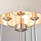Close-up of the Endon Brenley 3 Light Table Lamp showing brushed chrome triple-arm fitting, natural linen shade and reflective metallic inner lining.