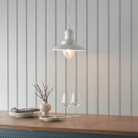 Endon Chartford cream gloss pendant light with shaped clear glass shade and chain suspension, hung above a wooden countertop against panelled walls.