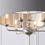 Close-up of Endon Brenley V2 6 Light Pendant in nickel and chrome, showing candle lamps beneath a grey linen shade with brushed metallic inner lining.